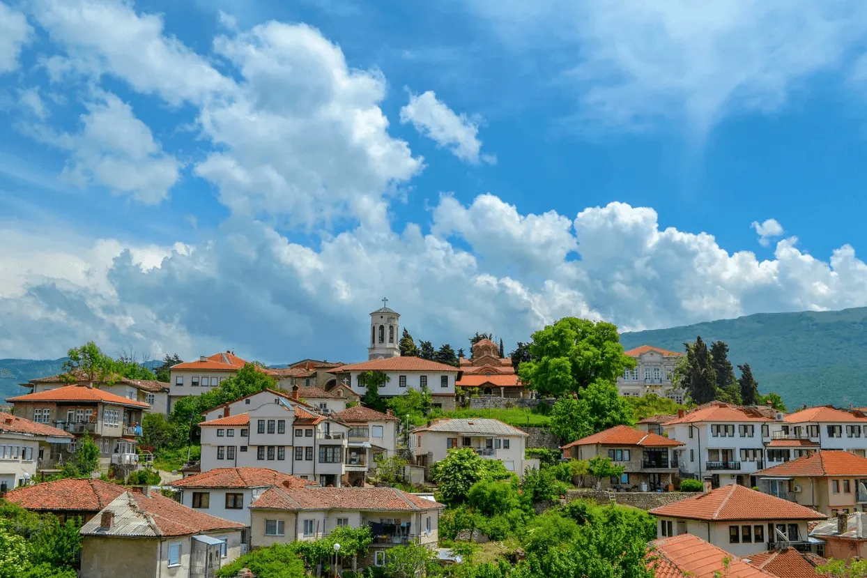 Vista de cidade europeia com casas de telhado vermelho entre montanhas